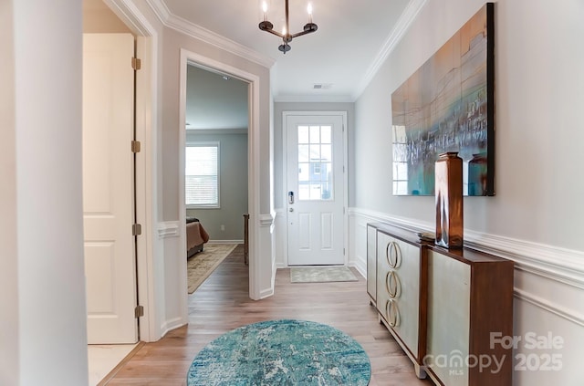 entryway featuring ornamental molding and light hardwood / wood-style floors