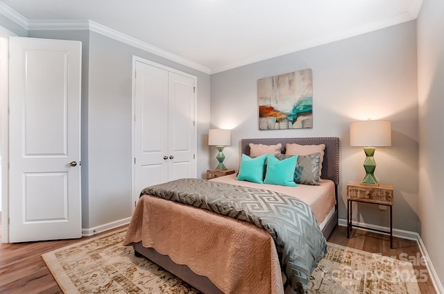 bedroom featuring wood-type flooring, ornamental molding, and a closet