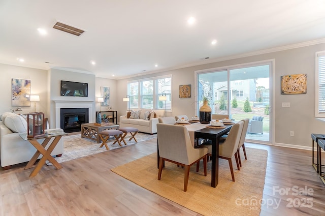 dining area featuring crown molding and light hardwood / wood-style floors