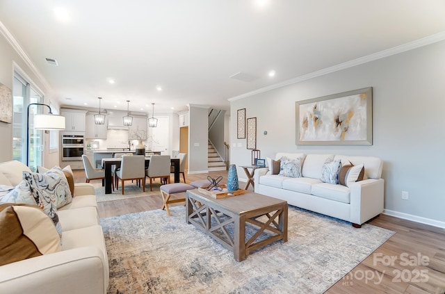 living room featuring ornamental molding and light wood-type flooring