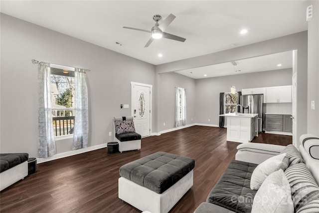 living room featuring ceiling fan and dark hardwood / wood-style flooring