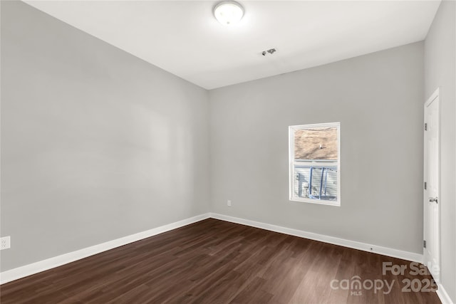 unfurnished room featuring dark wood-type flooring