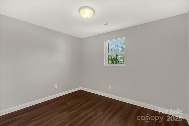 unfurnished room with dark hardwood / wood-style flooring