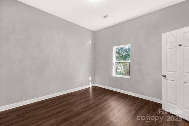 unfurnished room featuring dark wood-type flooring