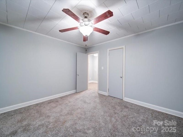 carpeted empty room with ceiling fan and ornamental molding