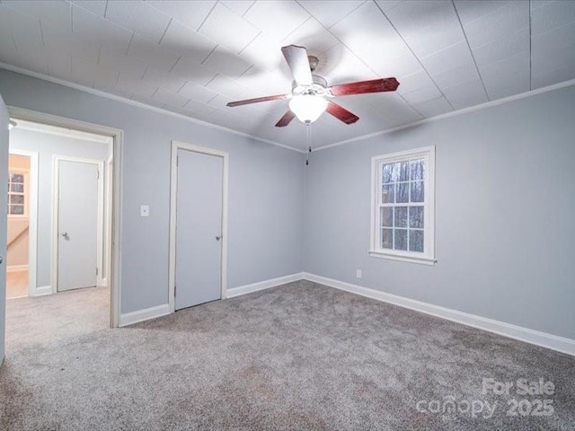 spare room with crown molding, ceiling fan, and light carpet