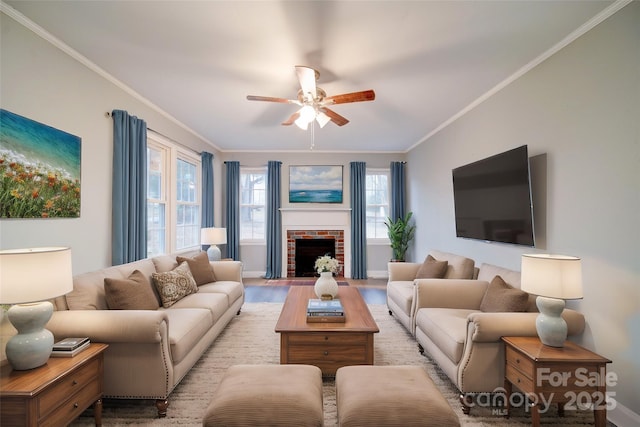 living room featuring ceiling fan, light wood-type flooring, crown molding, and a brick fireplace