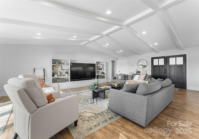 living room featuring hardwood / wood-style flooring, vaulted ceiling with beams, and built in features