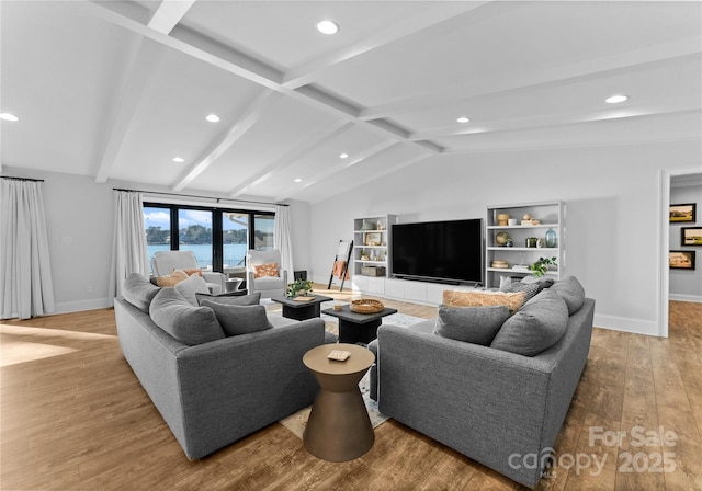 living room featuring lofted ceiling with beams and light hardwood / wood-style flooring