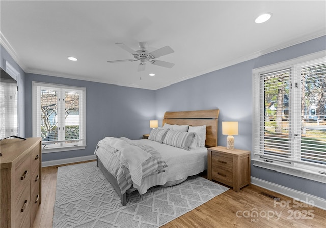 bedroom with ceiling fan, crown molding, and light wood-type flooring