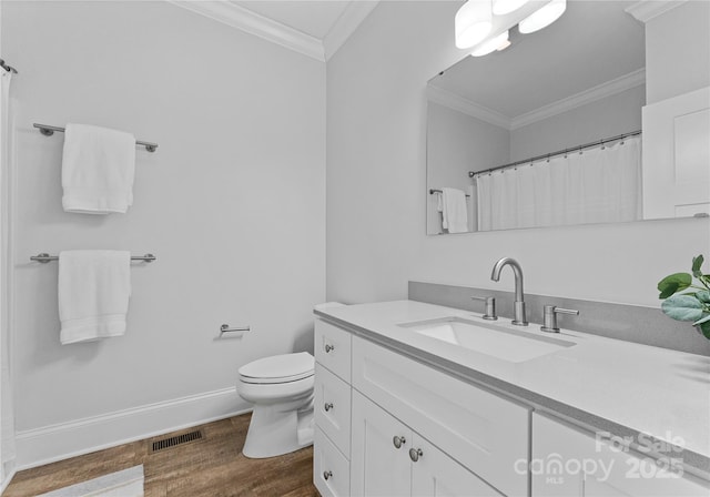 bathroom featuring toilet, vanity, wood-type flooring, and ornamental molding