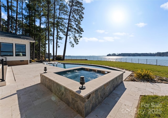 view of pool with an in ground hot tub, a yard, a water view, and a patio area