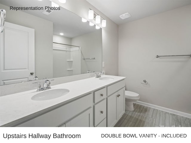 bathroom featuring vanity, toilet, and walk in shower