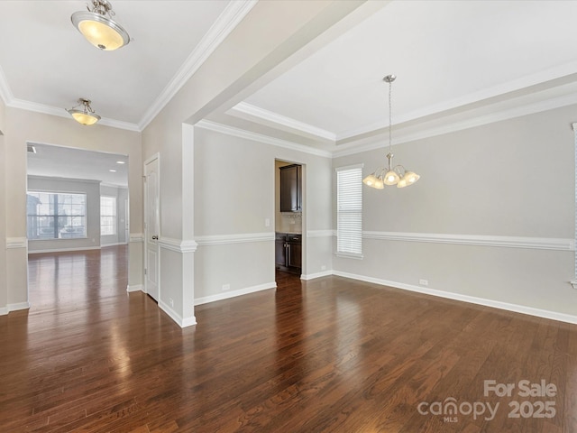 interior space featuring dark wood-type flooring, an inviting chandelier, a tray ceiling, and crown molding