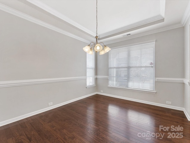 unfurnished room with a raised ceiling, dark hardwood / wood-style flooring, an inviting chandelier, and ornamental molding