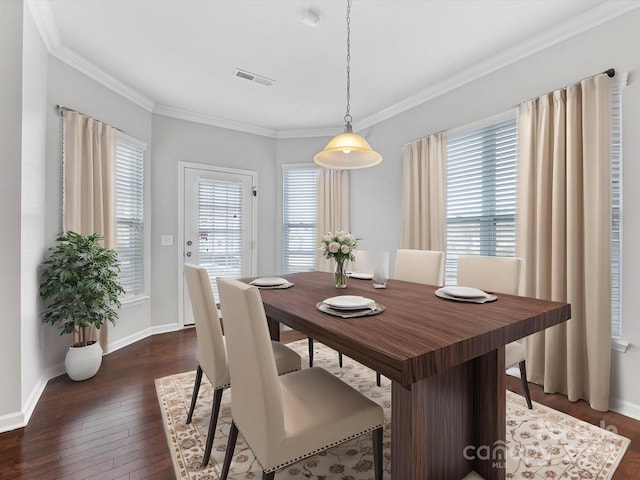 dining room featuring crown molding, dark hardwood / wood-style flooring, and a healthy amount of sunlight