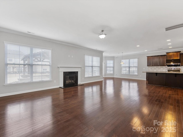 unfurnished living room with dark hardwood / wood-style floors and crown molding