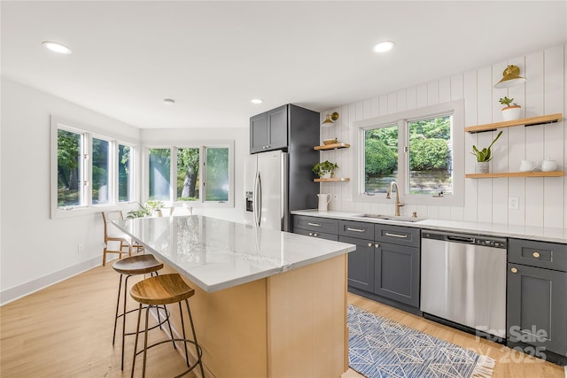 kitchen with gray cabinets, sink, a kitchen island, and stainless steel appliances