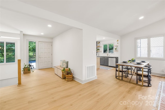 interior space featuring sink, vaulted ceiling, and light hardwood / wood-style flooring