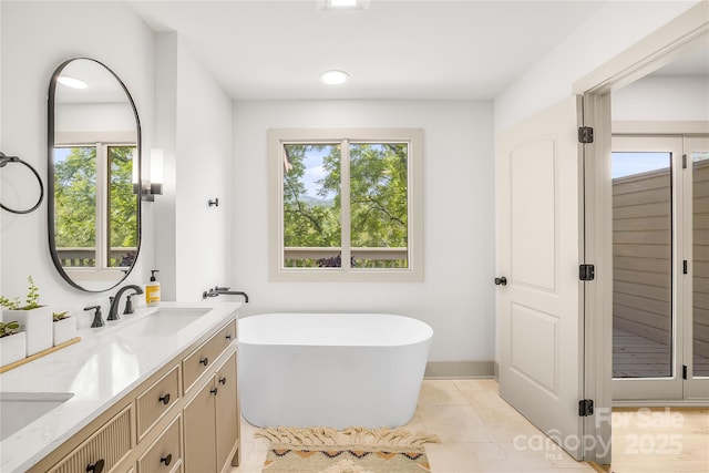 bathroom featuring tile patterned floors, a bathing tub, and plenty of natural light