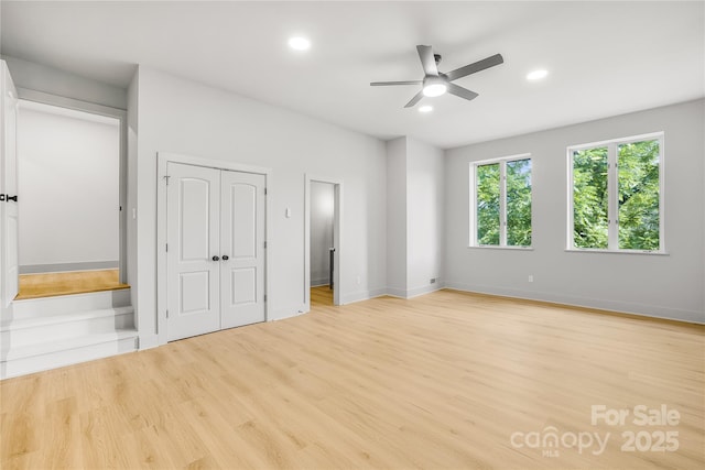 unfurnished bedroom with light wood-type flooring, ensuite bath, and ceiling fan