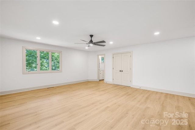 empty room with ceiling fan and light hardwood / wood-style floors