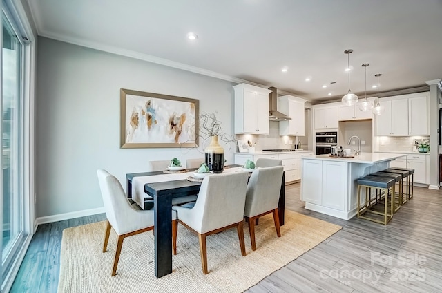 dining area featuring ornamental molding, recessed lighting, and light wood-style flooring