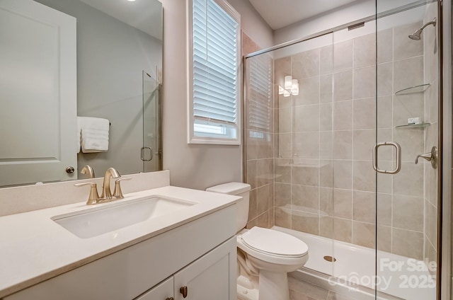 bathroom featuring toilet, a stall shower, and vanity