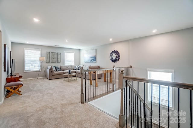 living room featuring recessed lighting, light colored carpet, and baseboards