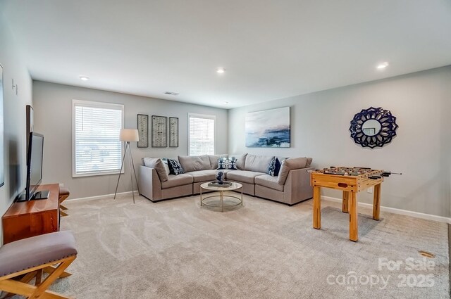 living room with recessed lighting, light carpet, visible vents, and baseboards