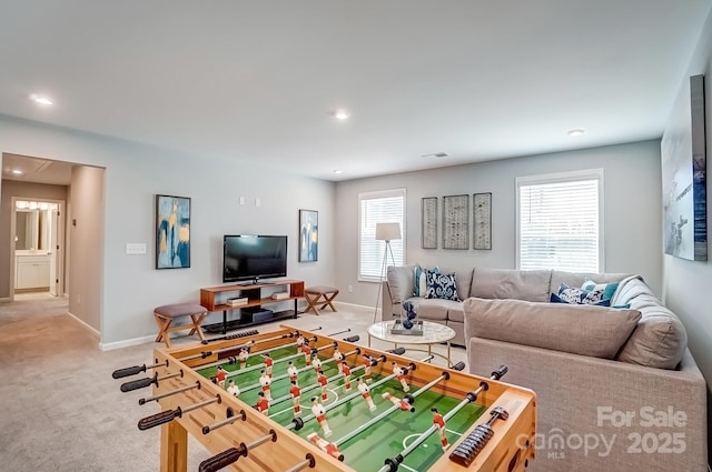 rec room with light carpet, a wealth of natural light, and baseboards