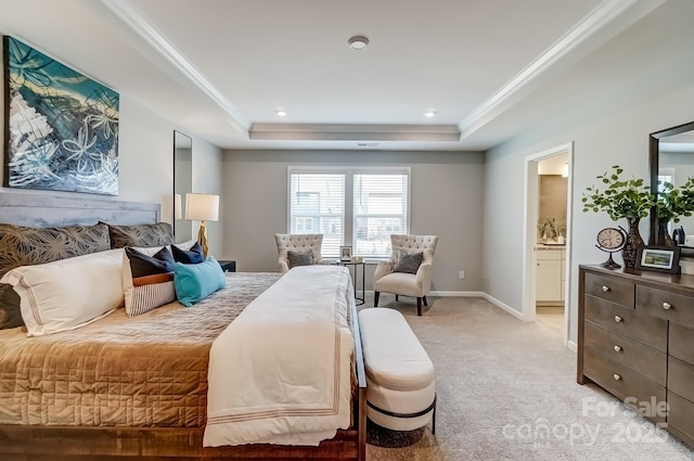 bedroom with baseboards, a raised ceiling, light colored carpet, ensuite bath, and ornamental molding