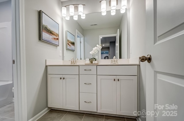 full bath featuring double vanity, baseboards, visible vents, tile patterned floors, and a sink