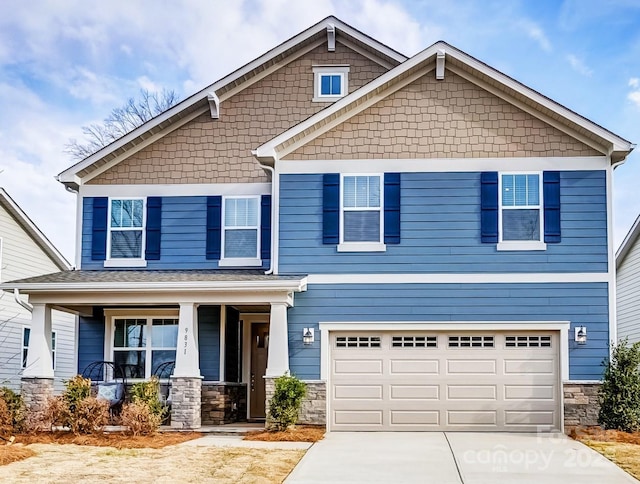 craftsman house with a garage, stone siding, a porch, and concrete driveway