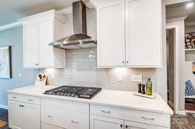 kitchen with crown molding, stainless steel gas cooktop, decorative backsplash, white cabinetry, and wall chimney exhaust hood