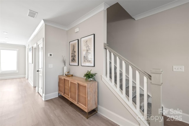 hallway featuring ornamental molding and light wood-type flooring