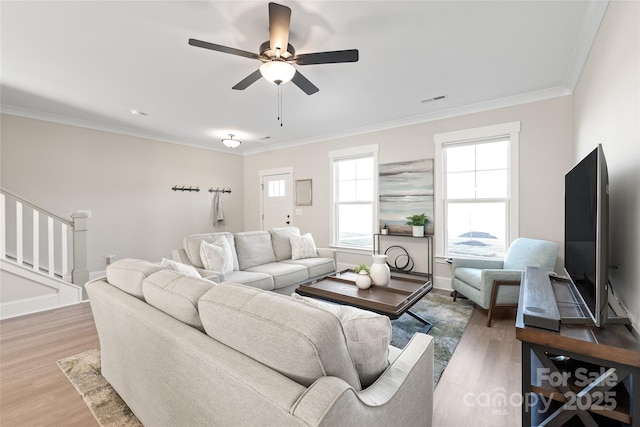 living room with hardwood / wood-style flooring, ornamental molding, and ceiling fan