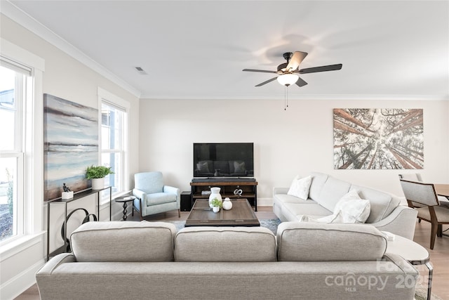 living room with ceiling fan, hardwood / wood-style flooring, ornamental molding, and a healthy amount of sunlight