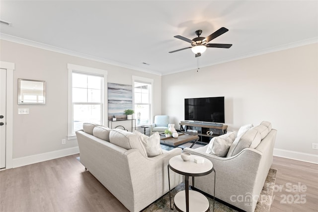 living room with hardwood / wood-style flooring, crown molding, and ceiling fan