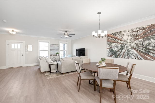 dining space with crown molding, ceiling fan with notable chandelier, and light hardwood / wood-style floors