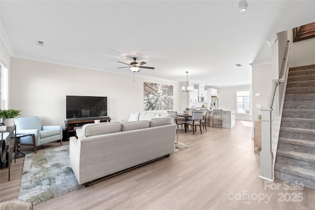 living room featuring crown molding, ceiling fan with notable chandelier, and light hardwood / wood-style flooring