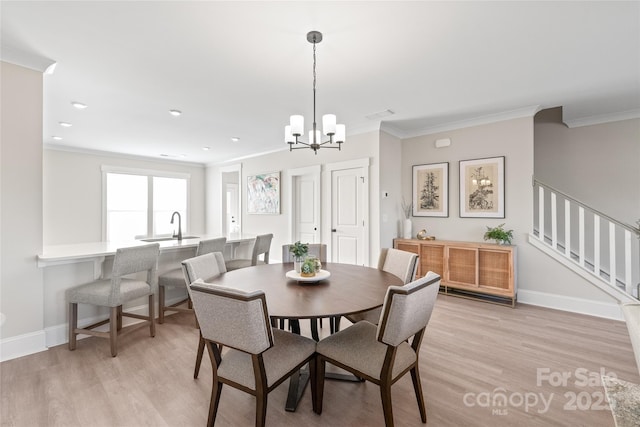 dining area featuring a notable chandelier, ornamental molding, and light hardwood / wood-style floors