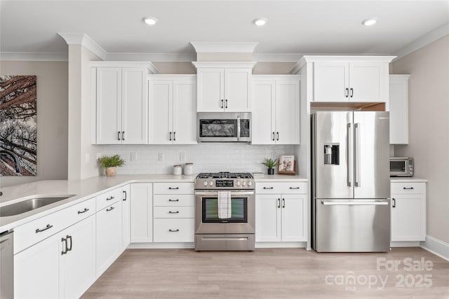 kitchen with appliances with stainless steel finishes, sink, and white cabinets