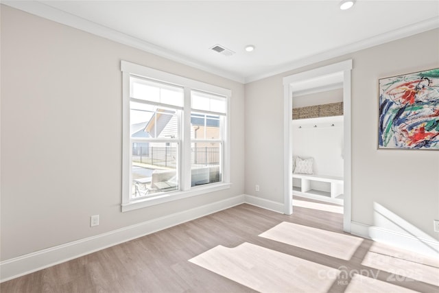 empty room featuring crown molding and light hardwood / wood-style floors