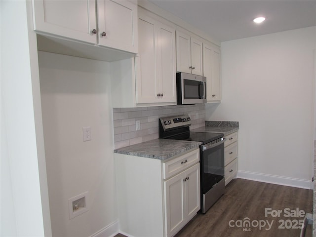 kitchen with light stone countertops, dark hardwood / wood-style flooring, tasteful backsplash, stainless steel appliances, and white cabinets