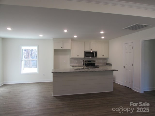 kitchen featuring stone counters, sink, dark hardwood / wood-style floors, appliances with stainless steel finishes, and white cabinetry