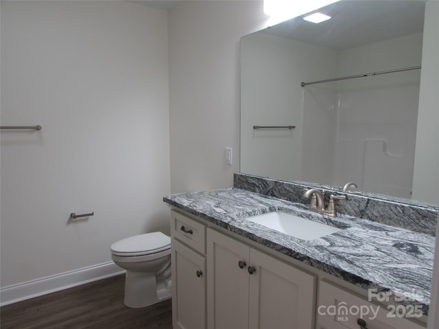 bathroom with a shower, hardwood / wood-style flooring, vanity, and toilet