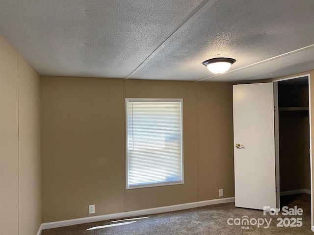 unfurnished bedroom featuring a textured ceiling, carpet floors, and a closet