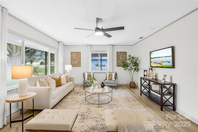 living room featuring light hardwood / wood-style floors and ceiling fan