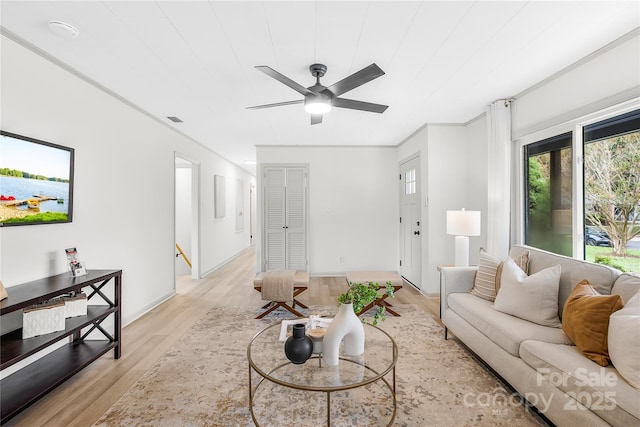 living room featuring light hardwood / wood-style floors, ceiling fan, and ornamental molding